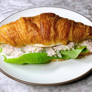 Tuna salad sandwich on croissant with lettuce