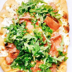 Pizza topped with everything that prosciutto and cheese