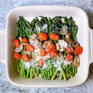 Asparagus mushrooms and tomatoes in a casserole dish