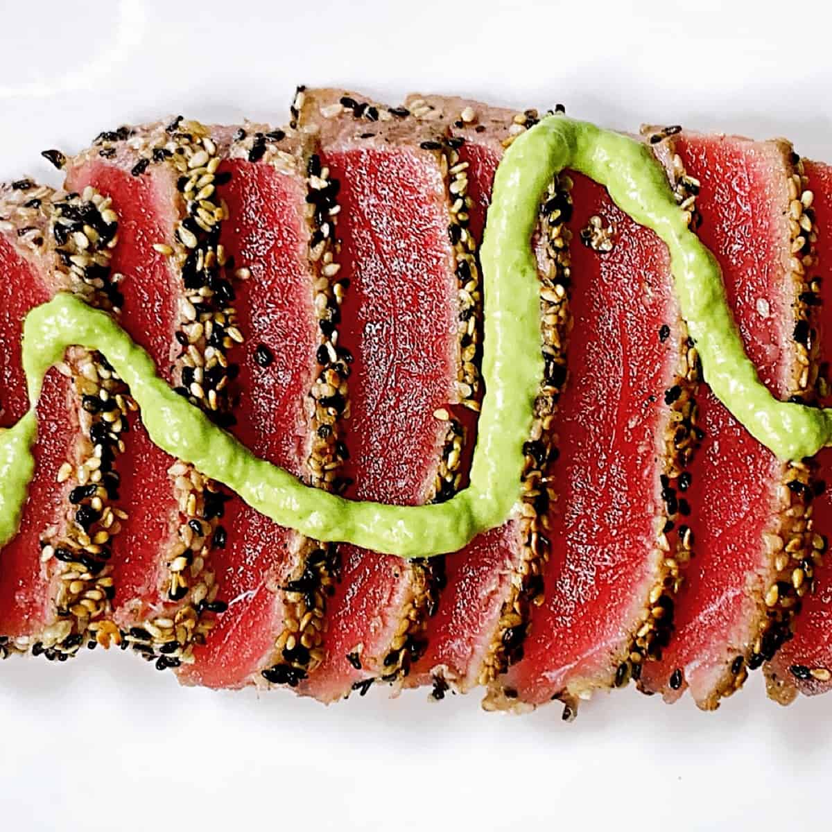 sesame crusted ahi tuna with wasabi on a white plate