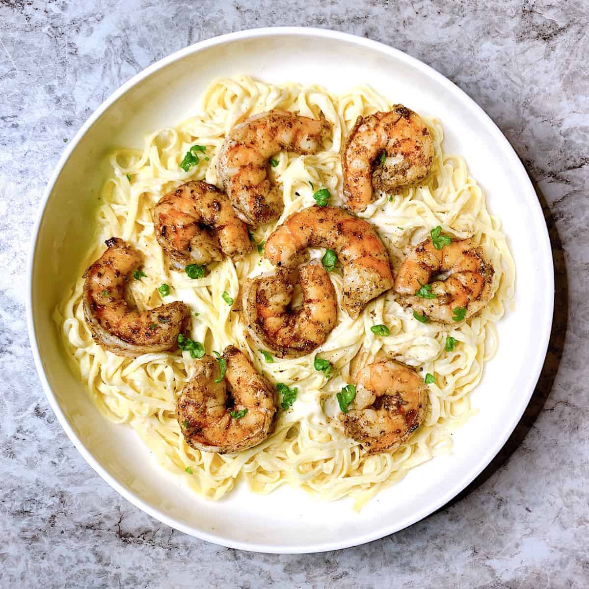 Linguini Alfredo with Blackened Shrimp​ in large pasta bowl