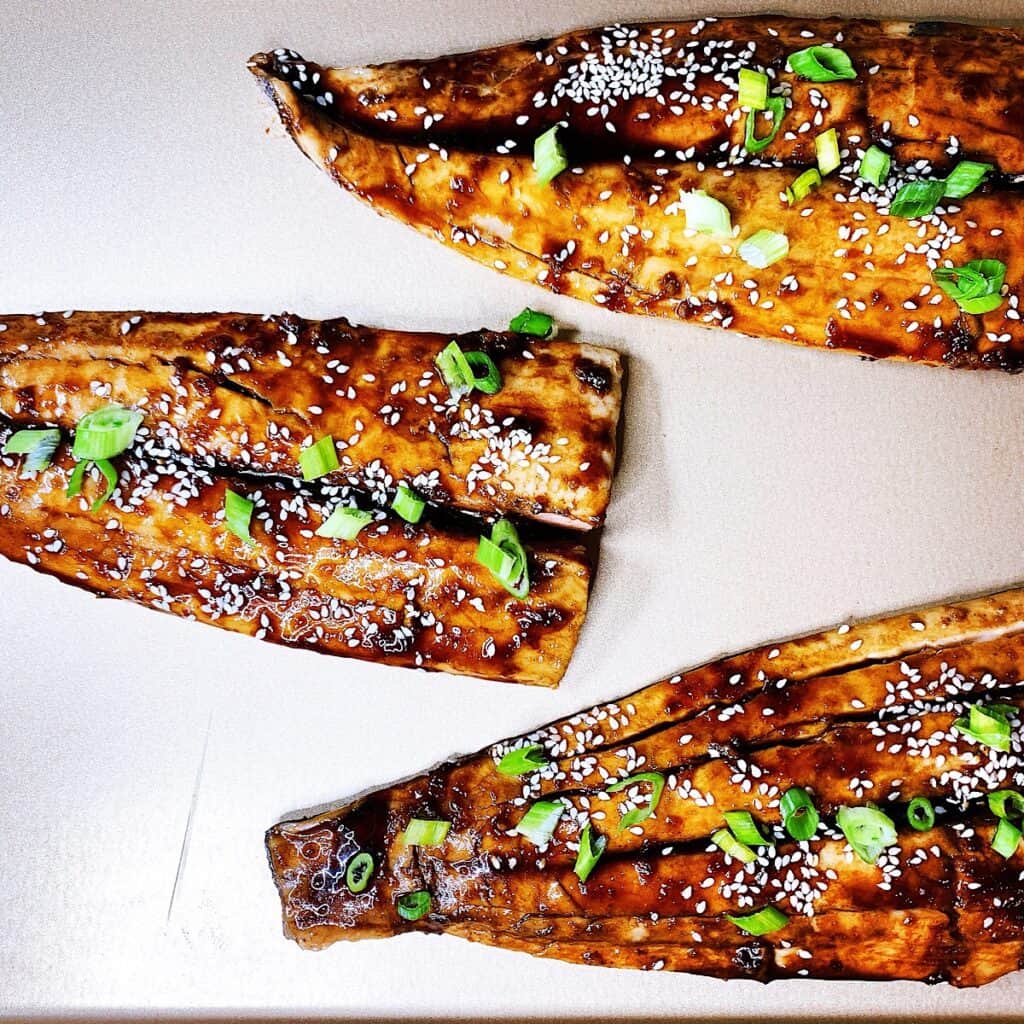 Sheet pan with honey soy ginger glazed Mahi Mahi topped with sesame seeds and green onions
