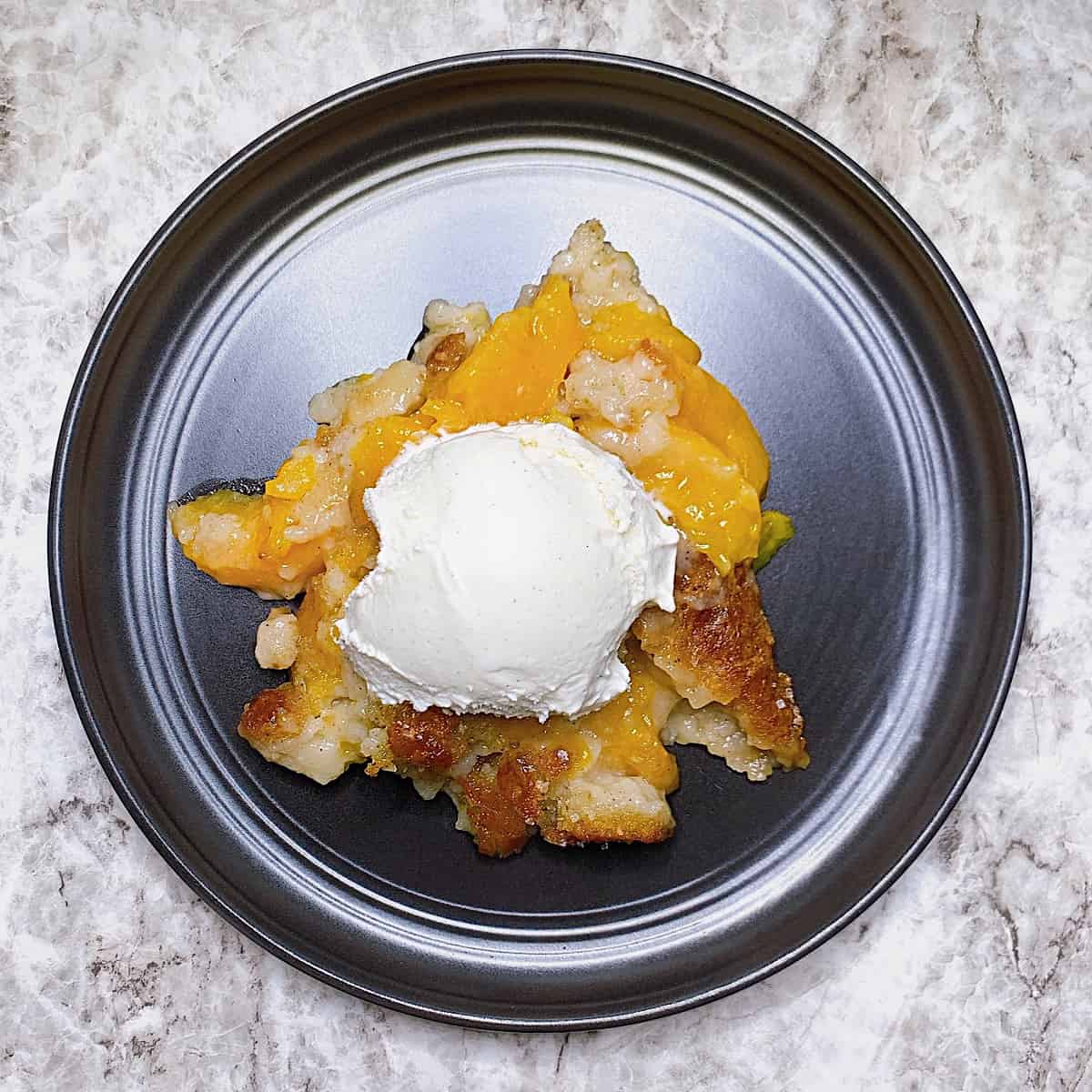 Peach cobbler with vanilla ice cream on top