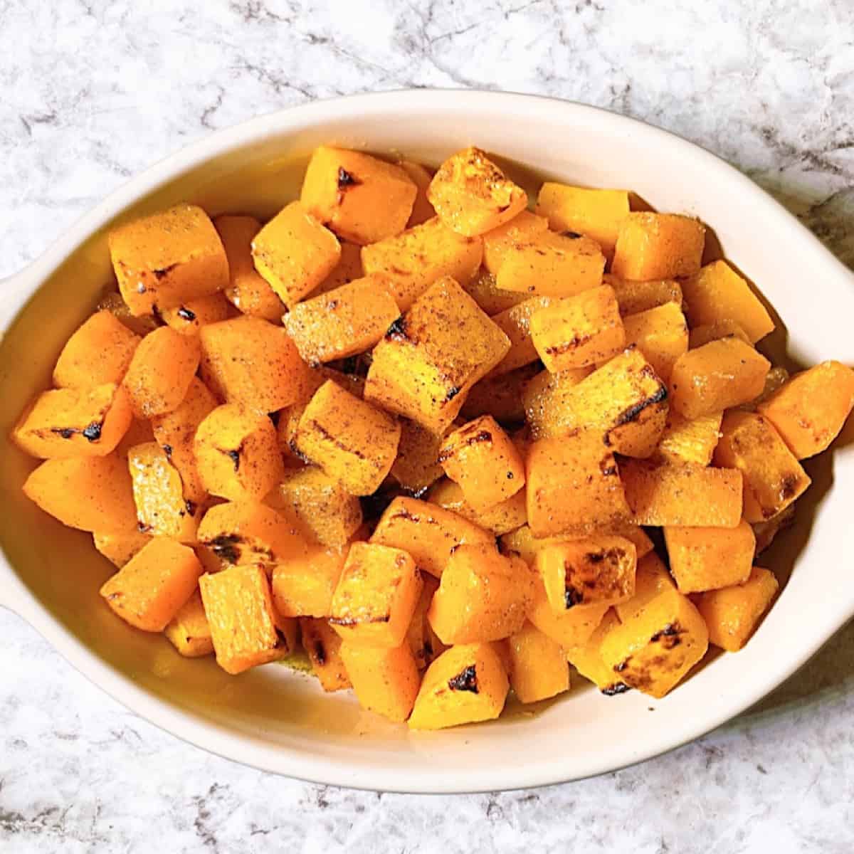 Casserole dish filled with roasted butternut squash and brown sugar glaze