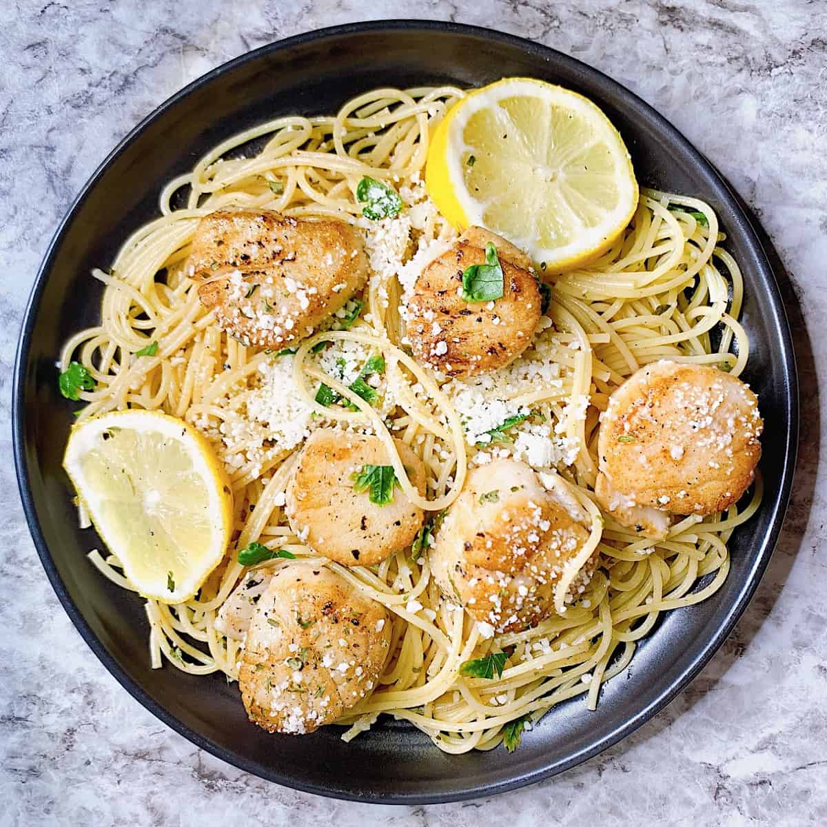 Scallops with Lemon Wine Butter Sauceโ on a black plate