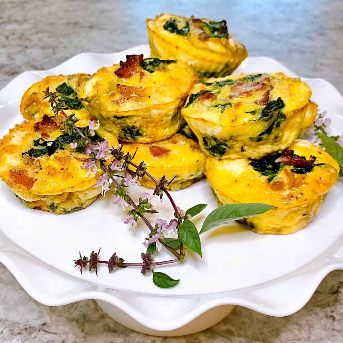 Mini Crustless quiche stacked on a cake platter with flowers