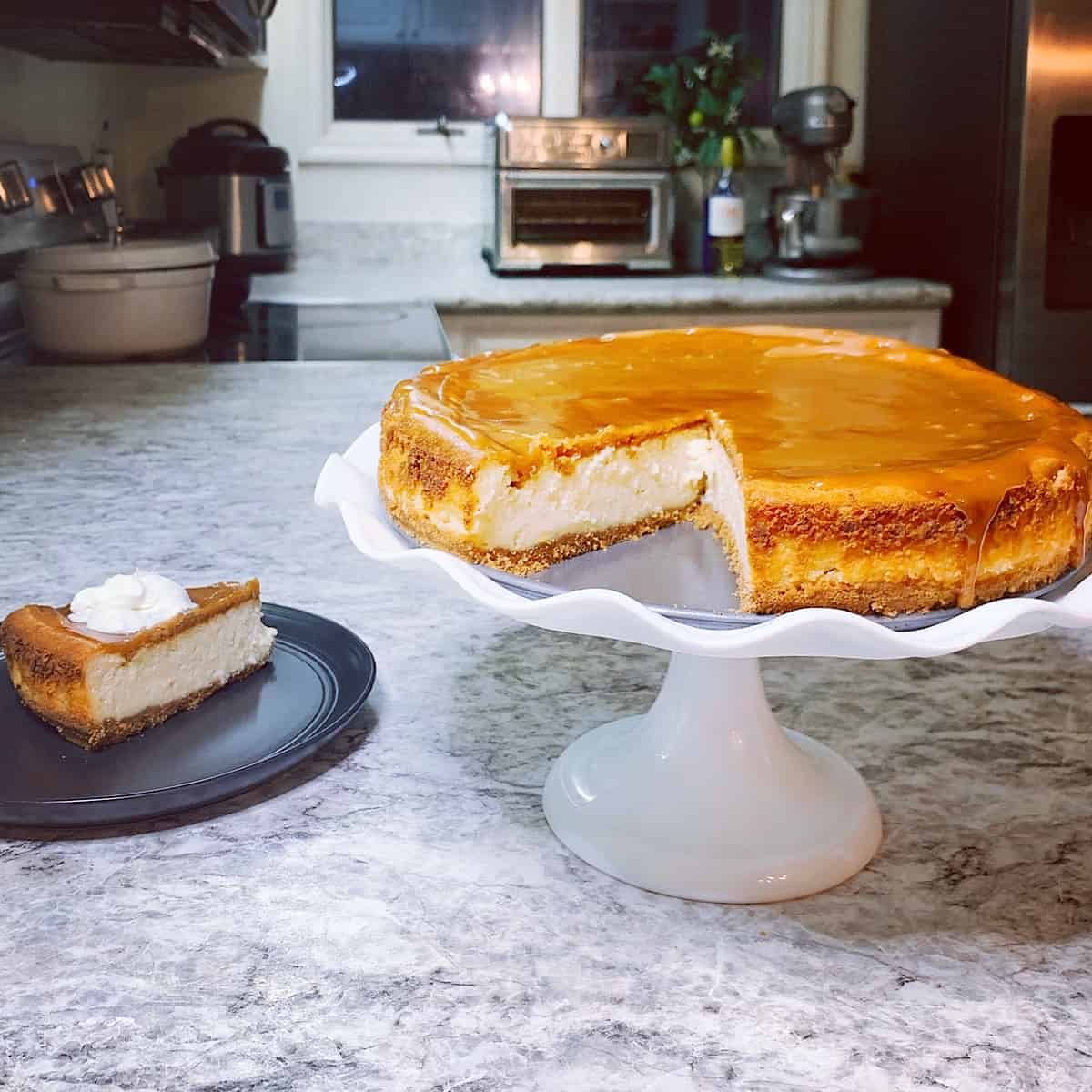Salted Caramel Cheesecake on a standing white cake platter