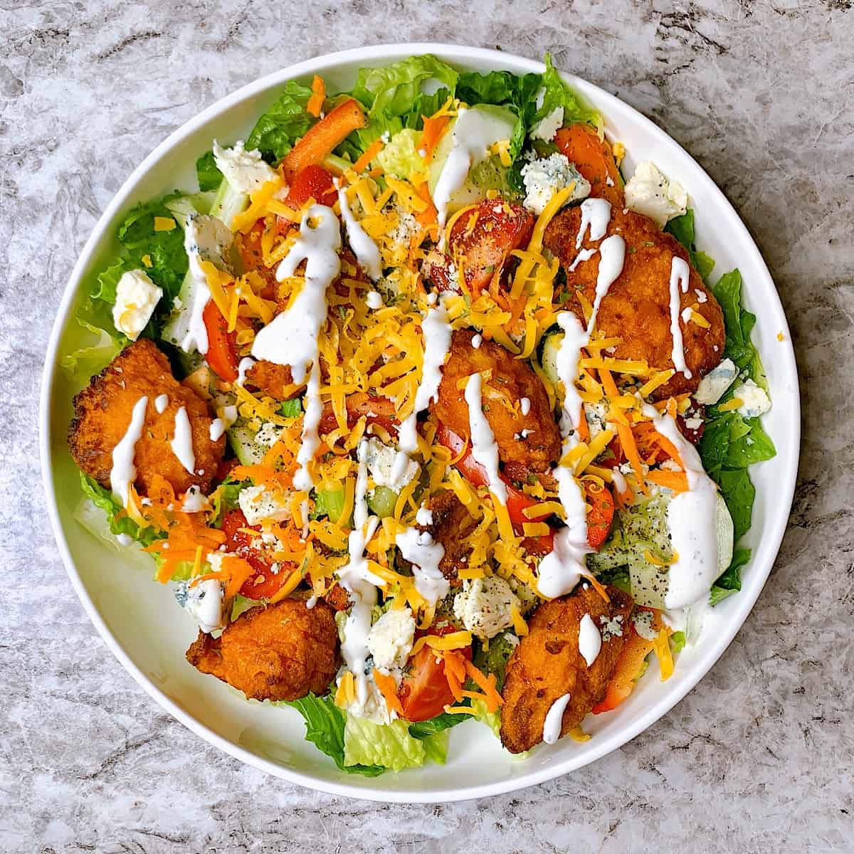Buffalo chicken salad with buttermilk ranch drizzled on top