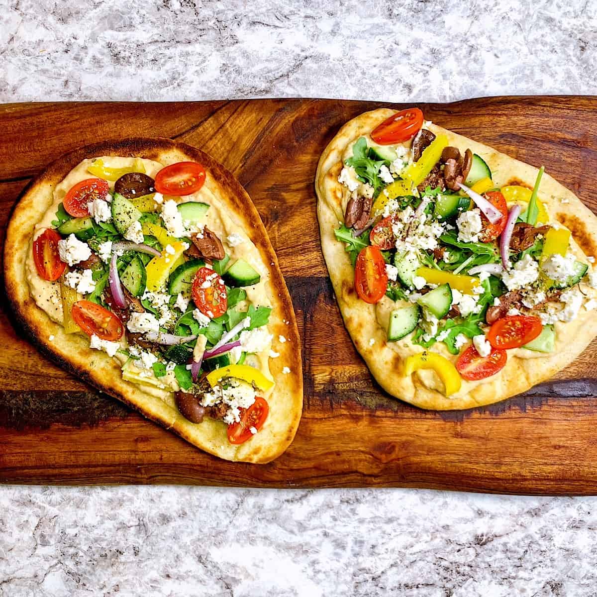 Mediterranean Garlic Flatbread with Hummusโ on wooden cutting board