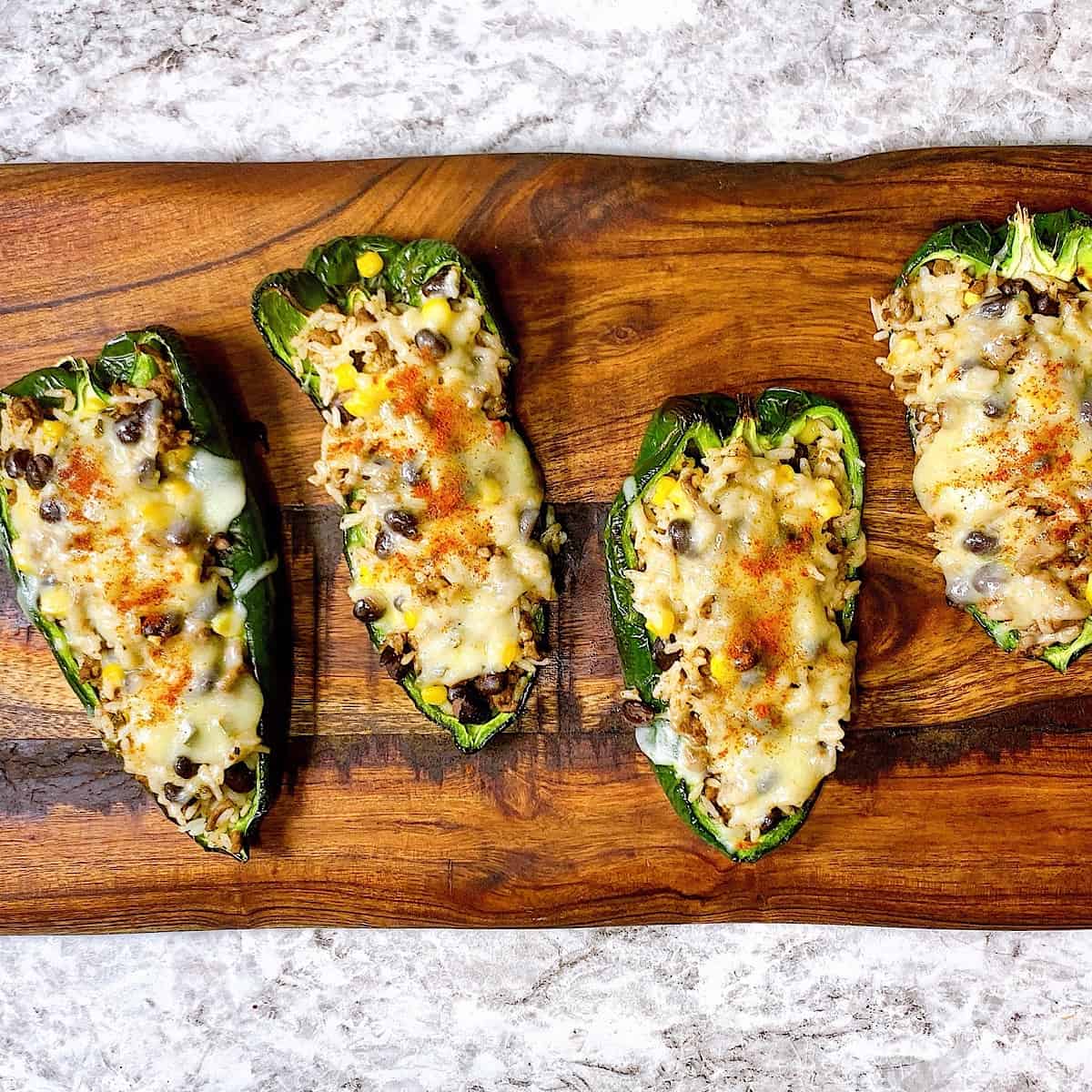 Stuffed poblano peppers on wooden cutting board