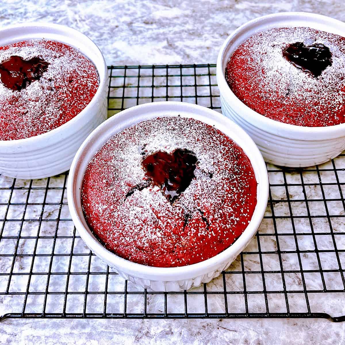 Red Velvet Lava Cakes topped with powdered sugar and a chocolate heart