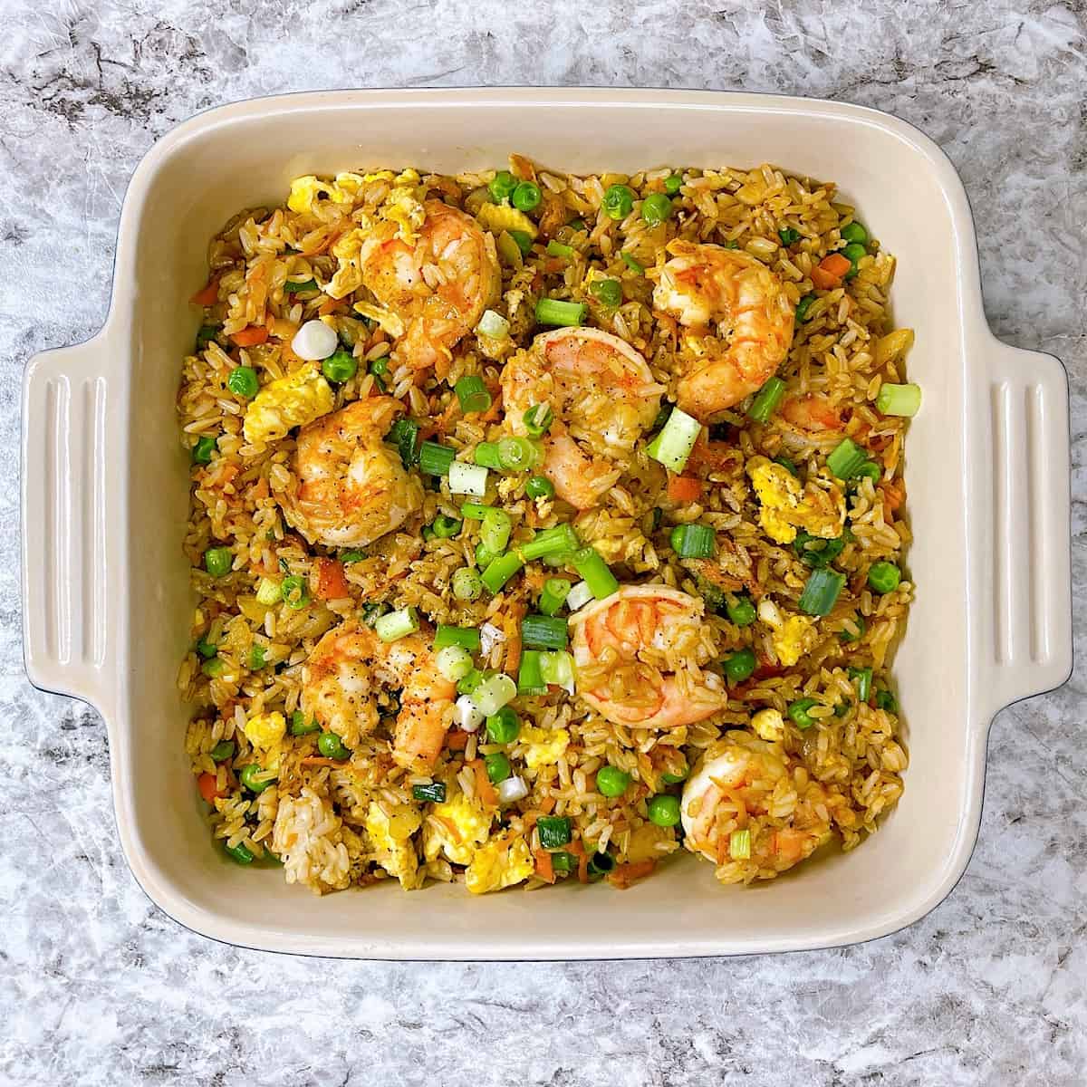 Shrimp fried rice in casserole dish topped with green onion