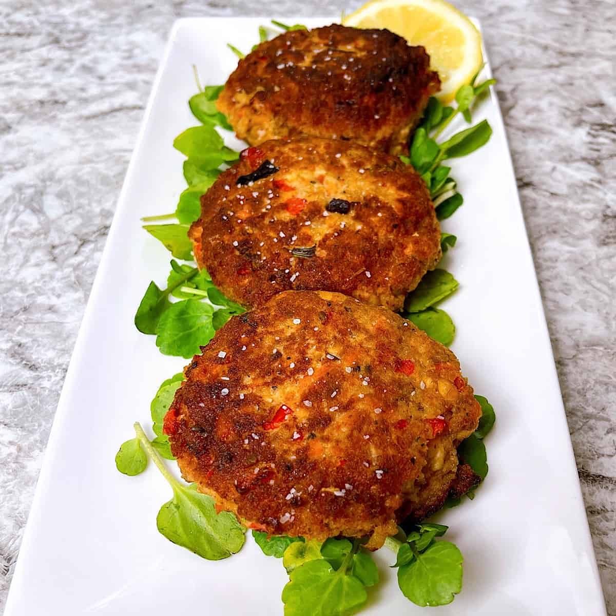 Salmon Croquettes on bed of lettuce with lemon