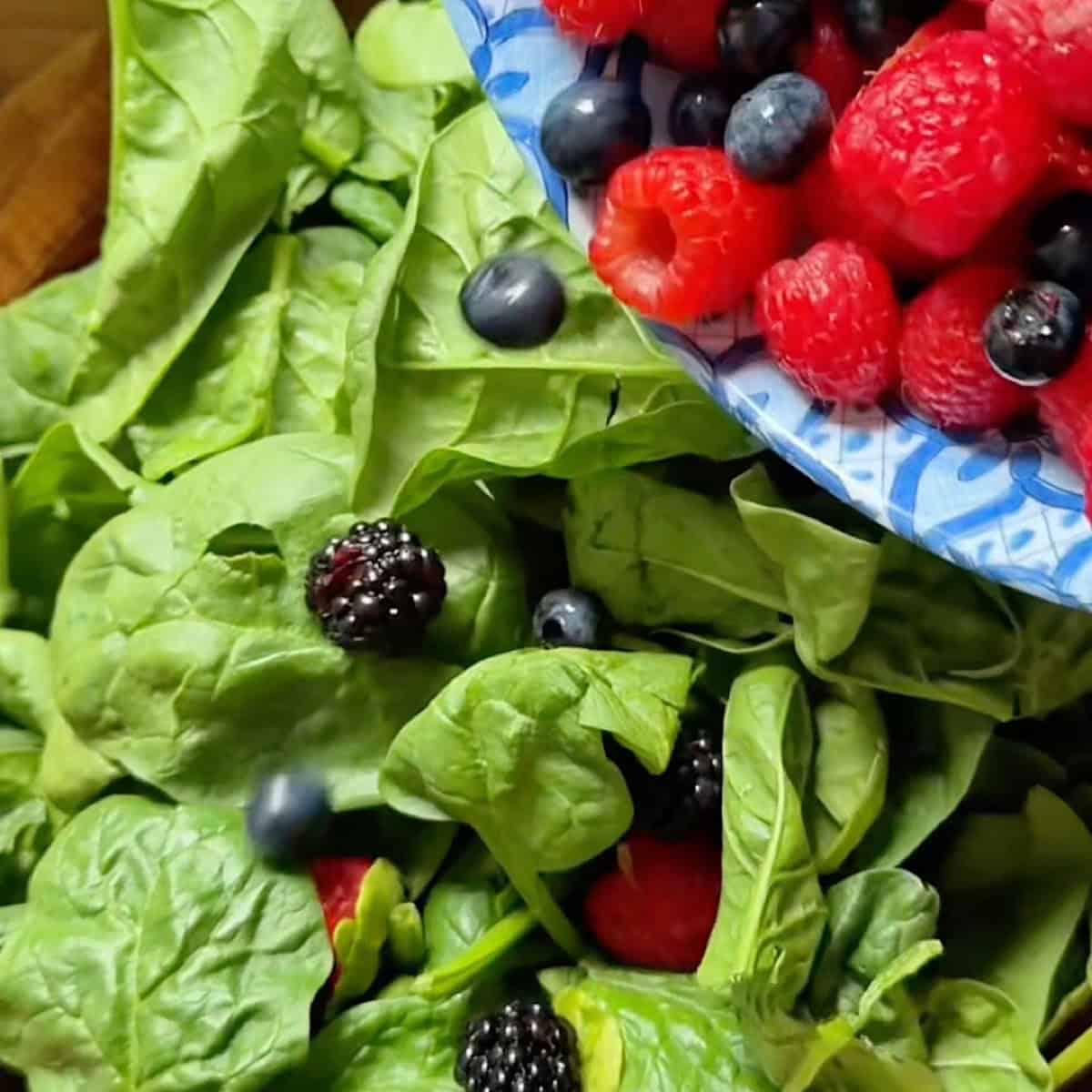 Layering mixed berries over the spinach.