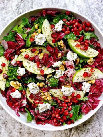 apple and pomegranate salad in white bowl