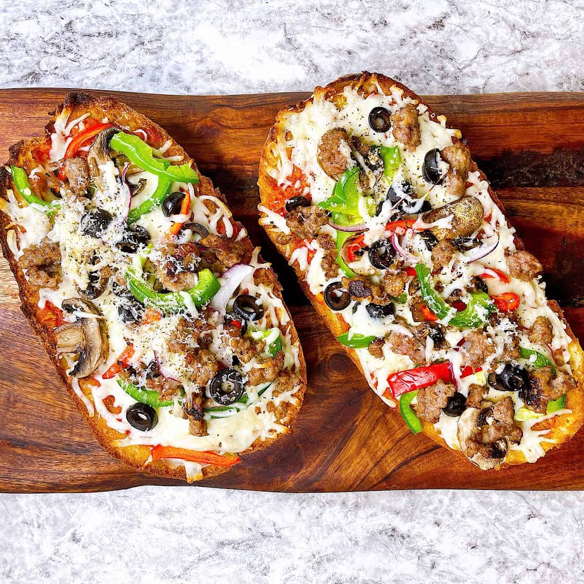 French Bread Pizza on cutting board with toppings