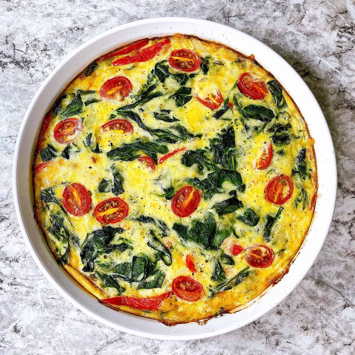 Crustless Spinach and Gruyere Quiche in white quiche dish