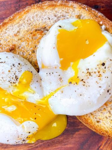 Sous vide poached eggs close up on toast with runny yolk
