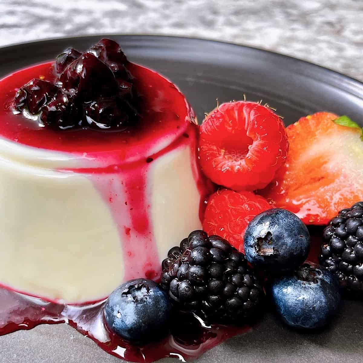 Single Serve Panna Cotta with Fruit Topping on black plate