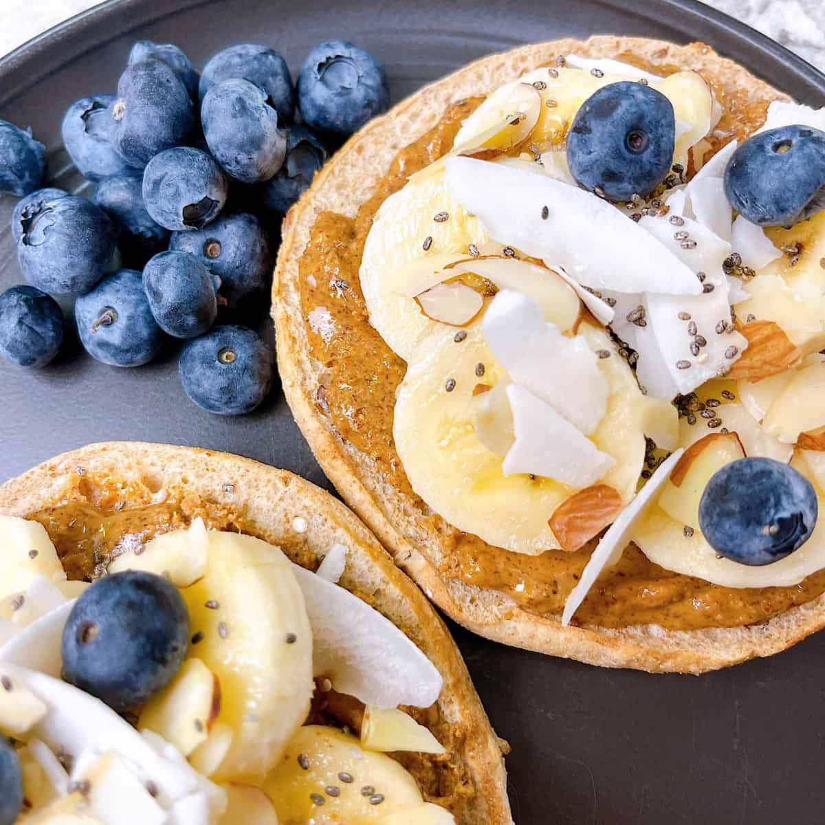Almond Butter Banana Crunch Toast close up on black plate with blueberries