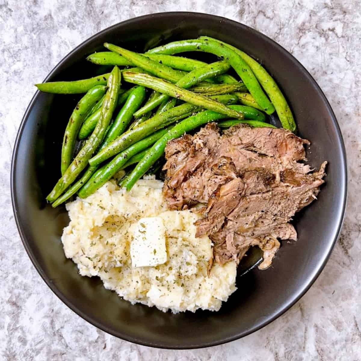Braised Boneless Lamb with Cauliflower Mashed Potatoes in black bowl