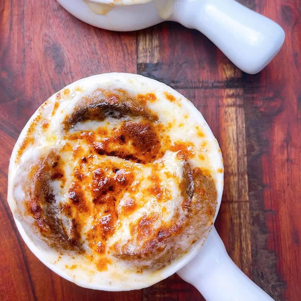 French onion soup in small crock with melted cheese