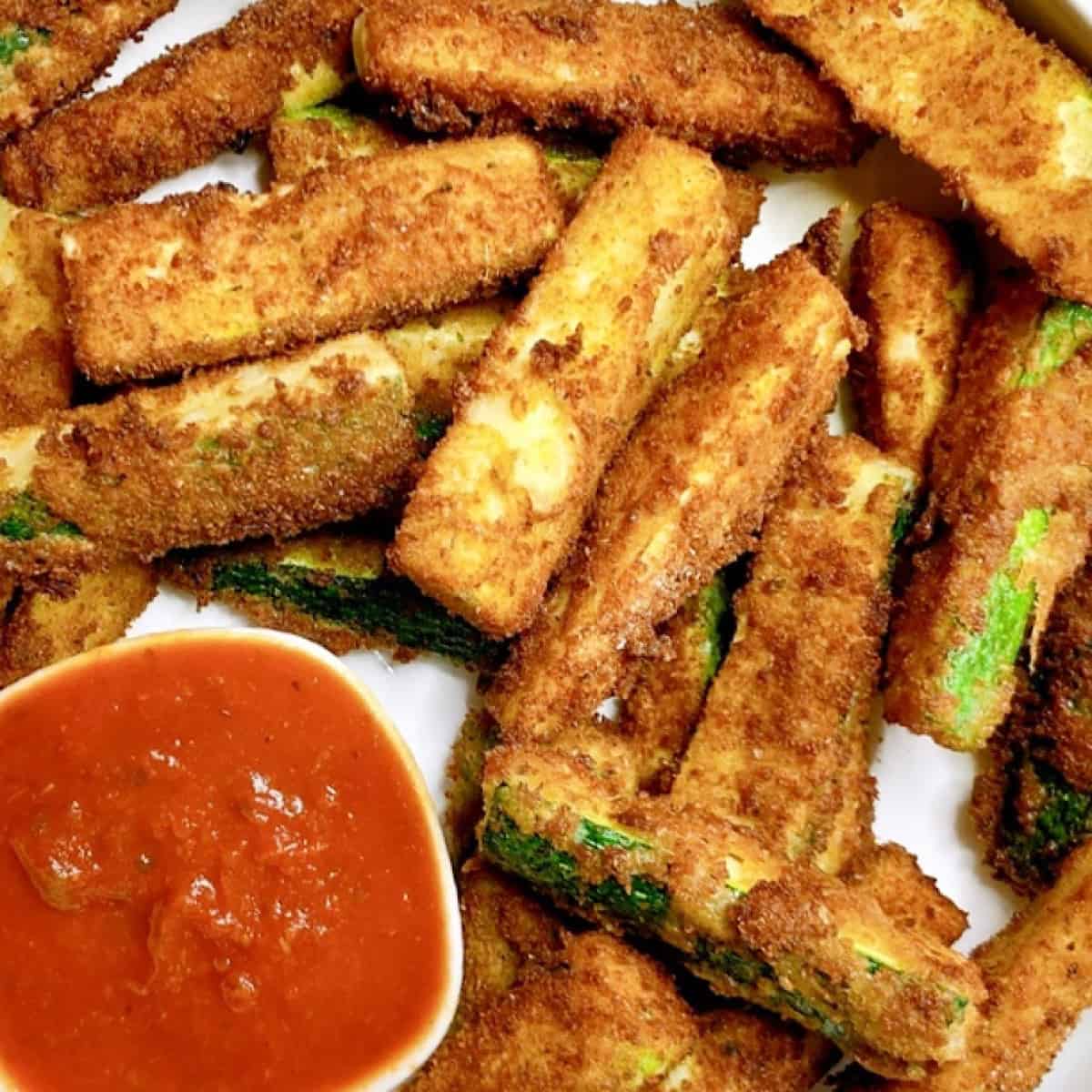 Fried zucchini on platter with marinara sauce