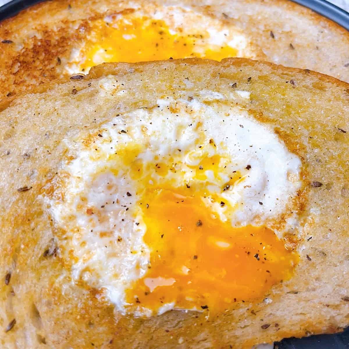 Eggs in the Nest on Rye close up with runny yolk