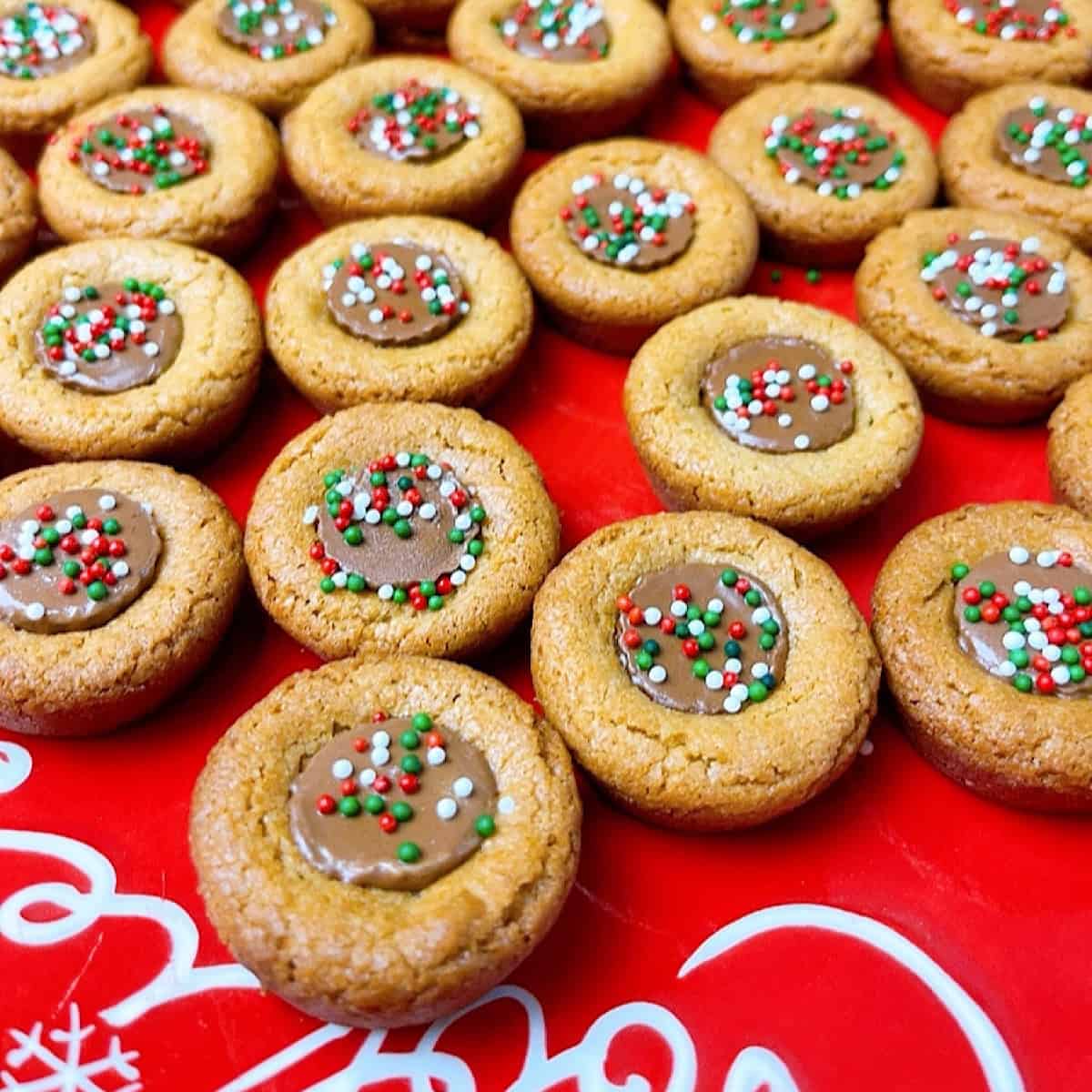 Peanut Butter Cup Cookies with sprinkles on a red Christmas plate