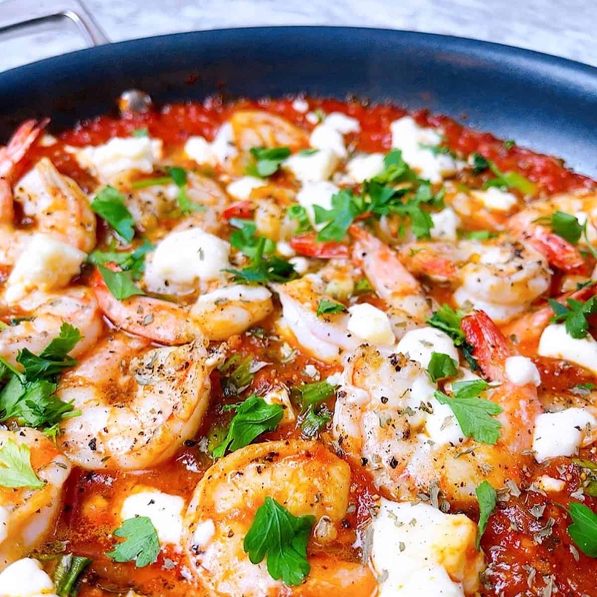 Shrimp Saganaki in pan with parsley and feta