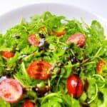 close up of arugula side salad with balsamic glaze