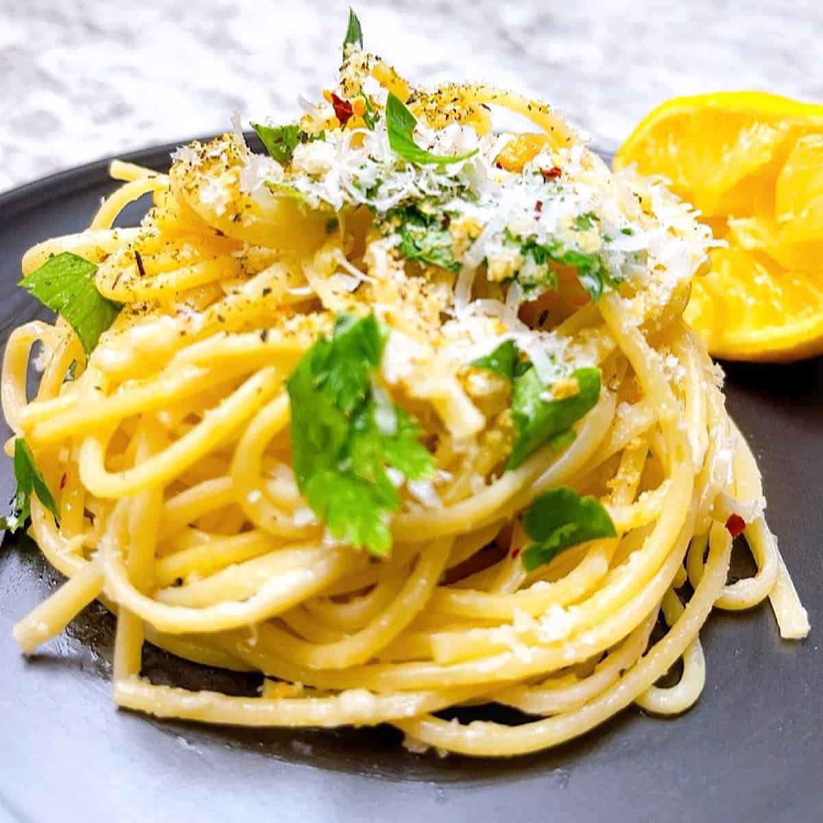 Spaghetti Aglio e Olio with Lemon twirled and garnished with parsley and parmesan