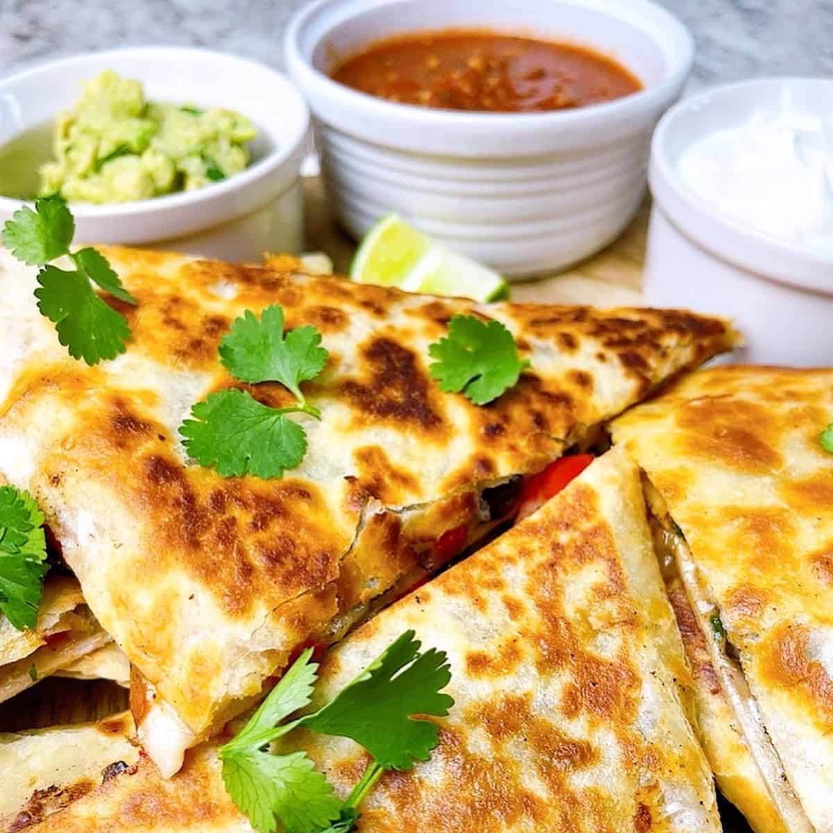 Veggie Quesadillas close up with salsa sour cream and guacamole