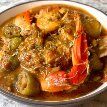 Close up bowl of seafood gumbo with crab claws and shrimp