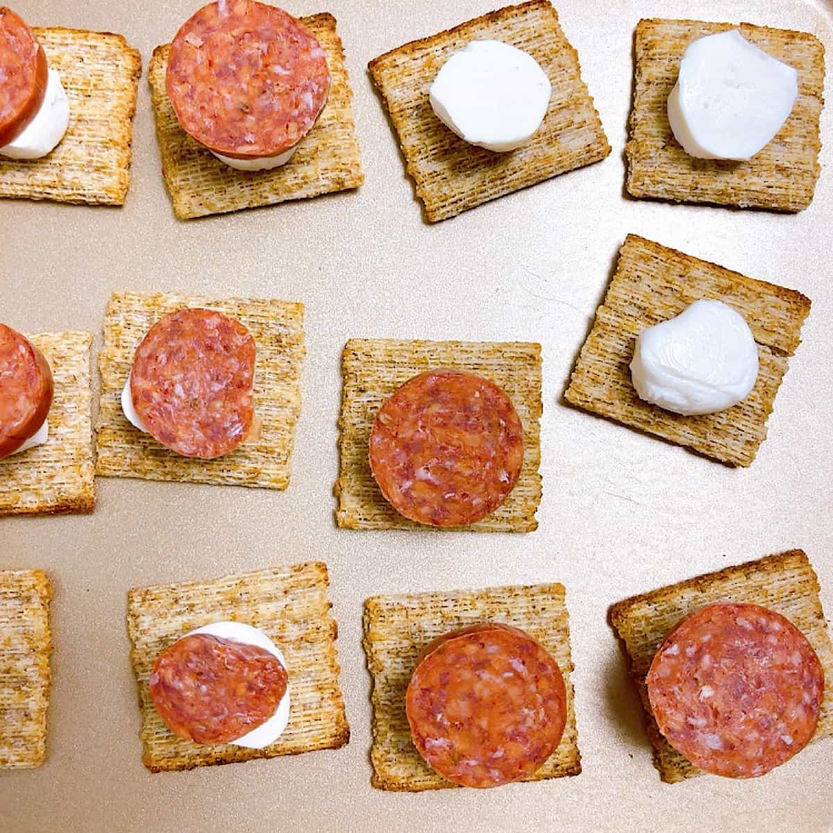 Easy Triscuit Pizza Bites process shot of cut pepperoni and cheese
