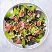 Fig and Prosciutto Salad with Goat Cheese and Balsamic in white bowl