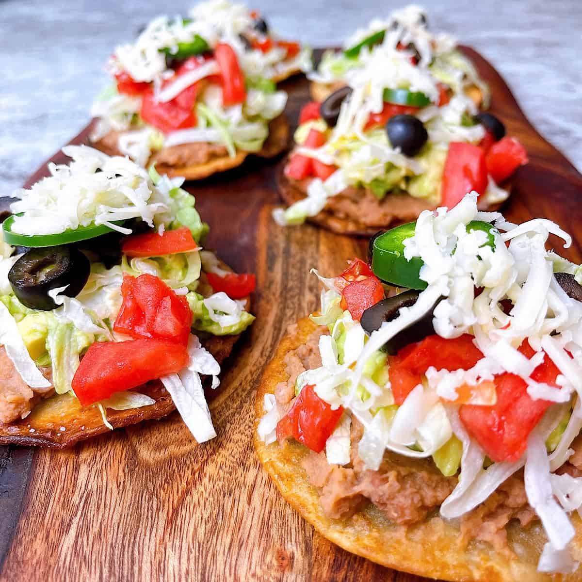 healthy air fryer tostadas mexicanas with canned or homemade refried beans close up on cutting board