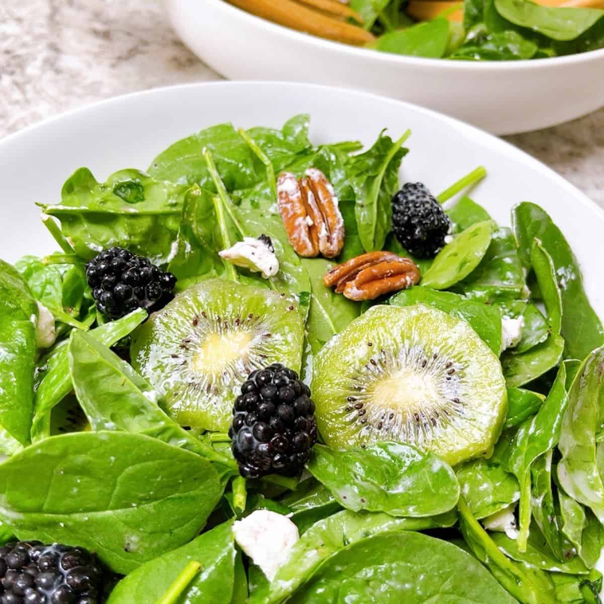 Side salad kiwi salad with blackberries and pecans tossed