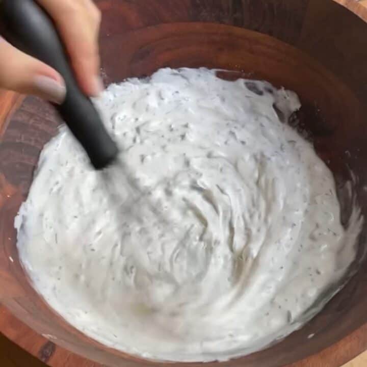 Creamy Cucumber Radish Salad Process Shot whisking ingredients.