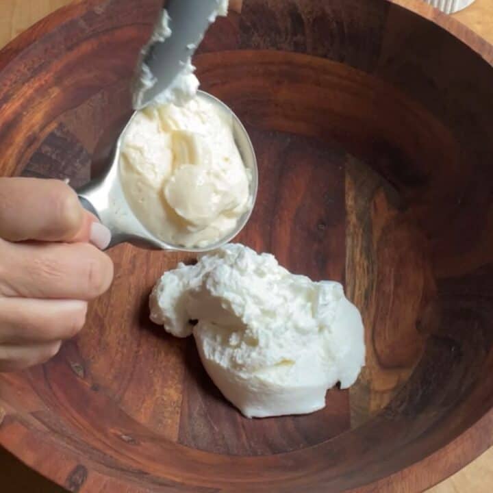 Creamy Cucumber Radish Salad Process Shot adding yogurt to bowl.