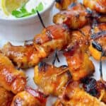 Bacon wrapped salmon bites feature image with dipping sauce.