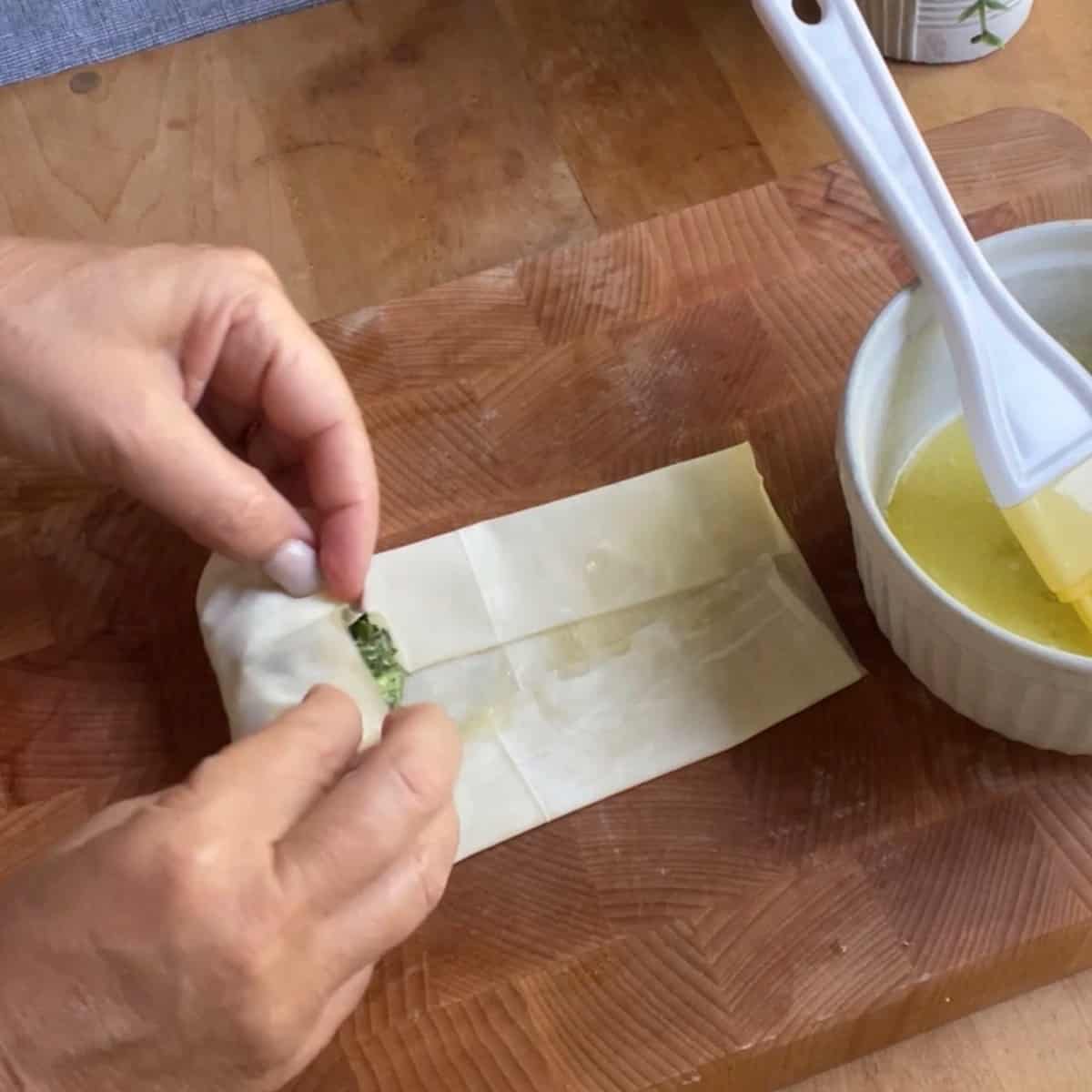 Spinach and feta being rolled up in phyllo process shot 5