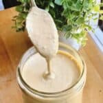 The best cajun sauce remoulade feature image sauce in jar with spoon dipping into it