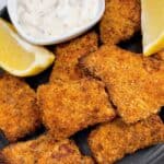 Air fryer fish fingers close up feature image with lemon and tartar sauce