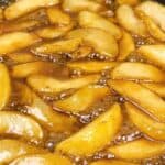 Bubbly hot caramelized apple slices in skillet.