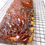low and slow oven baked ribs foil method feature image cooked rib rack with caramelized sauce