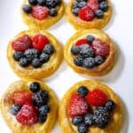 Mini cream cheese puff pastry bites 4th of July celebration feature image. 6 on white platter with powdered sugar.