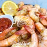 Peel and eat shrimp feature image in platter with cocktail sauce and lemon