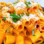 Spicy rigatoni carbone feature image close up with basil and parmesan