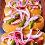 gourmet hot dogs with cornichons and pickled onions chicago style feature image close up of three dogs dressed